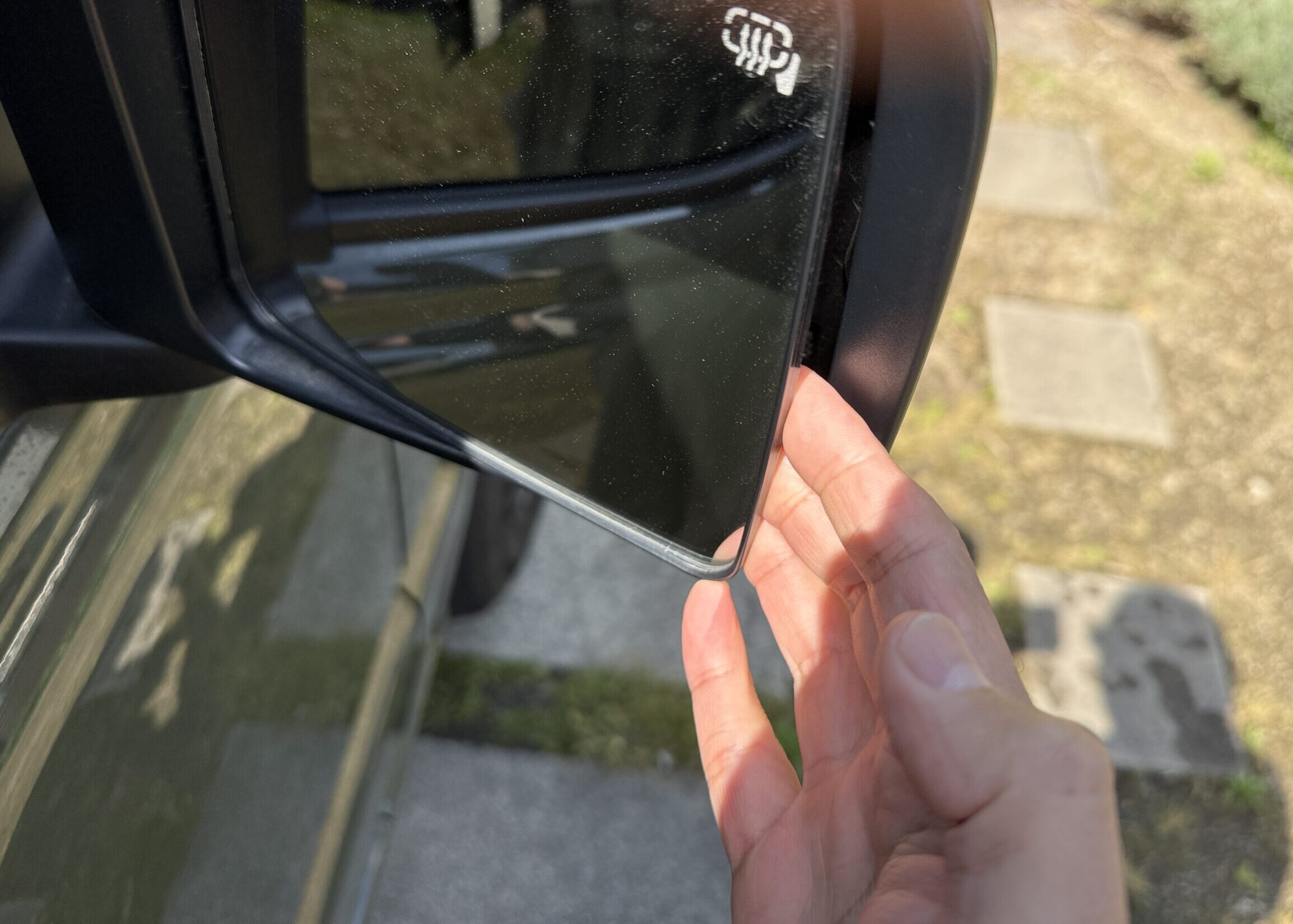 ジムニーの右ミラーの下から手を入れている