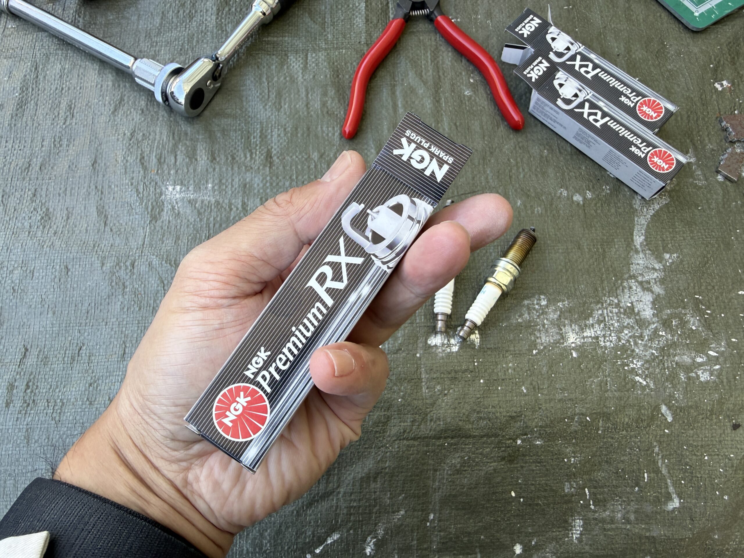 NGKのプラグの箱と左手