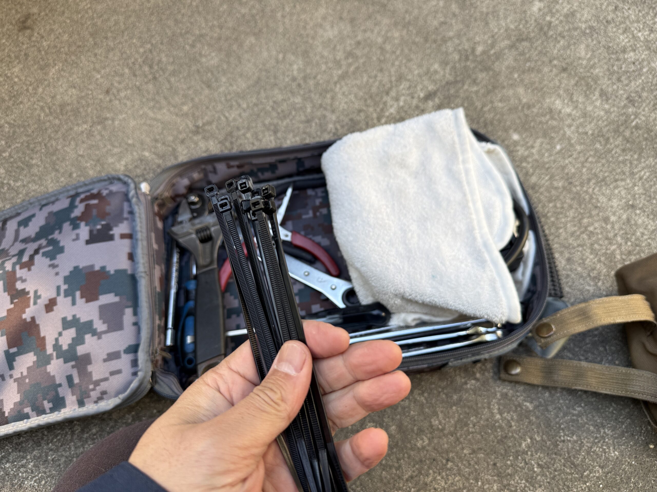 結束バンドと左手とバッグ