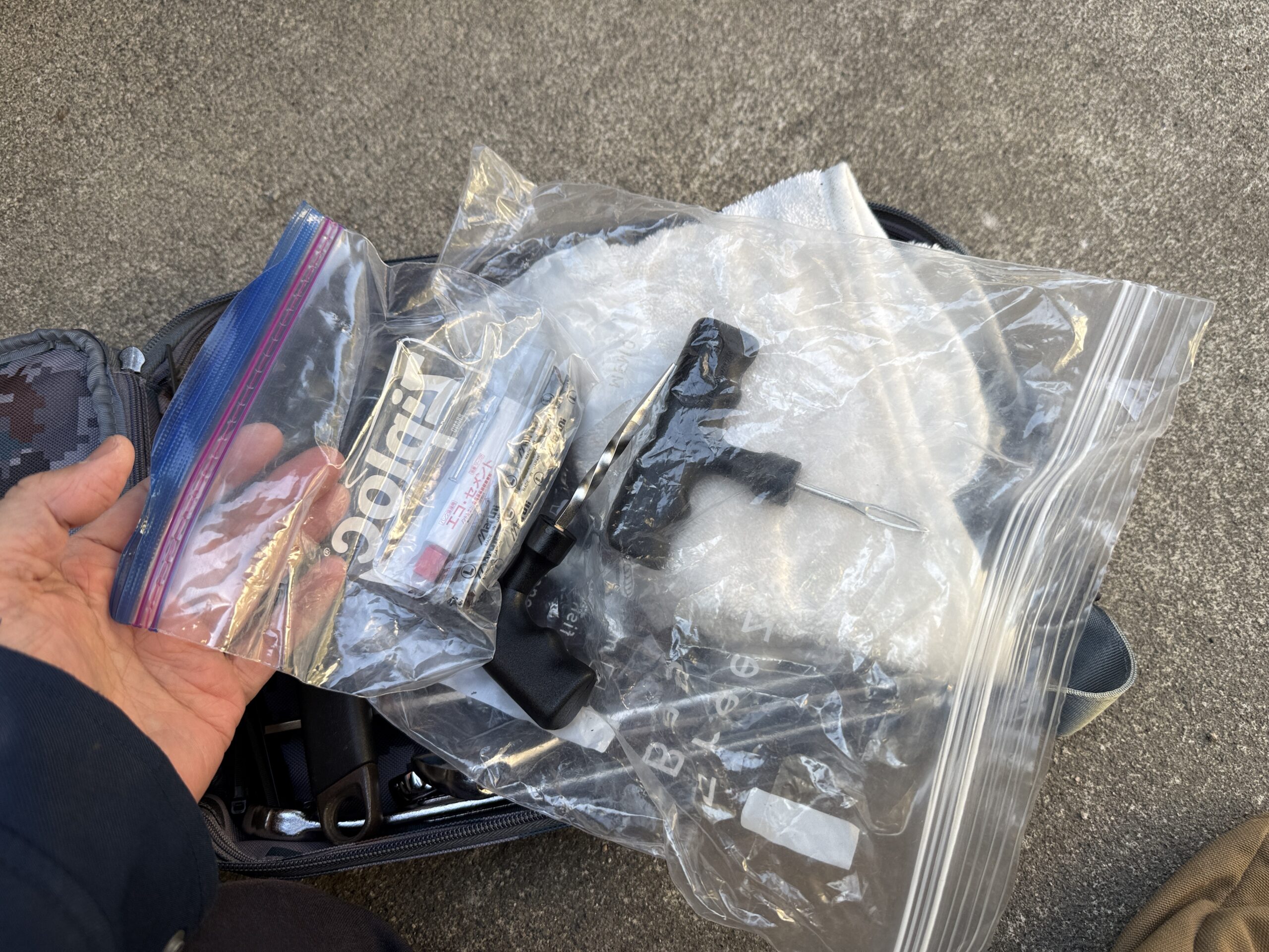 パンク修理キットよ左手とバッグ