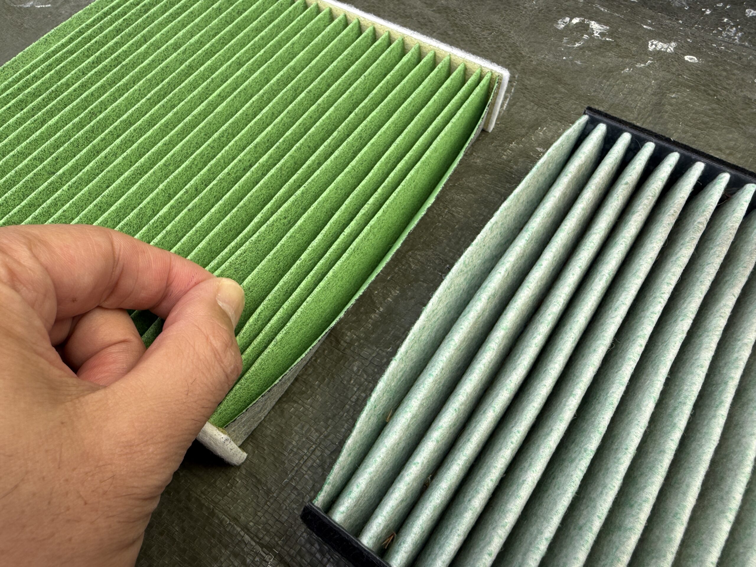 素材の違いを確認しているエアコンフィルター