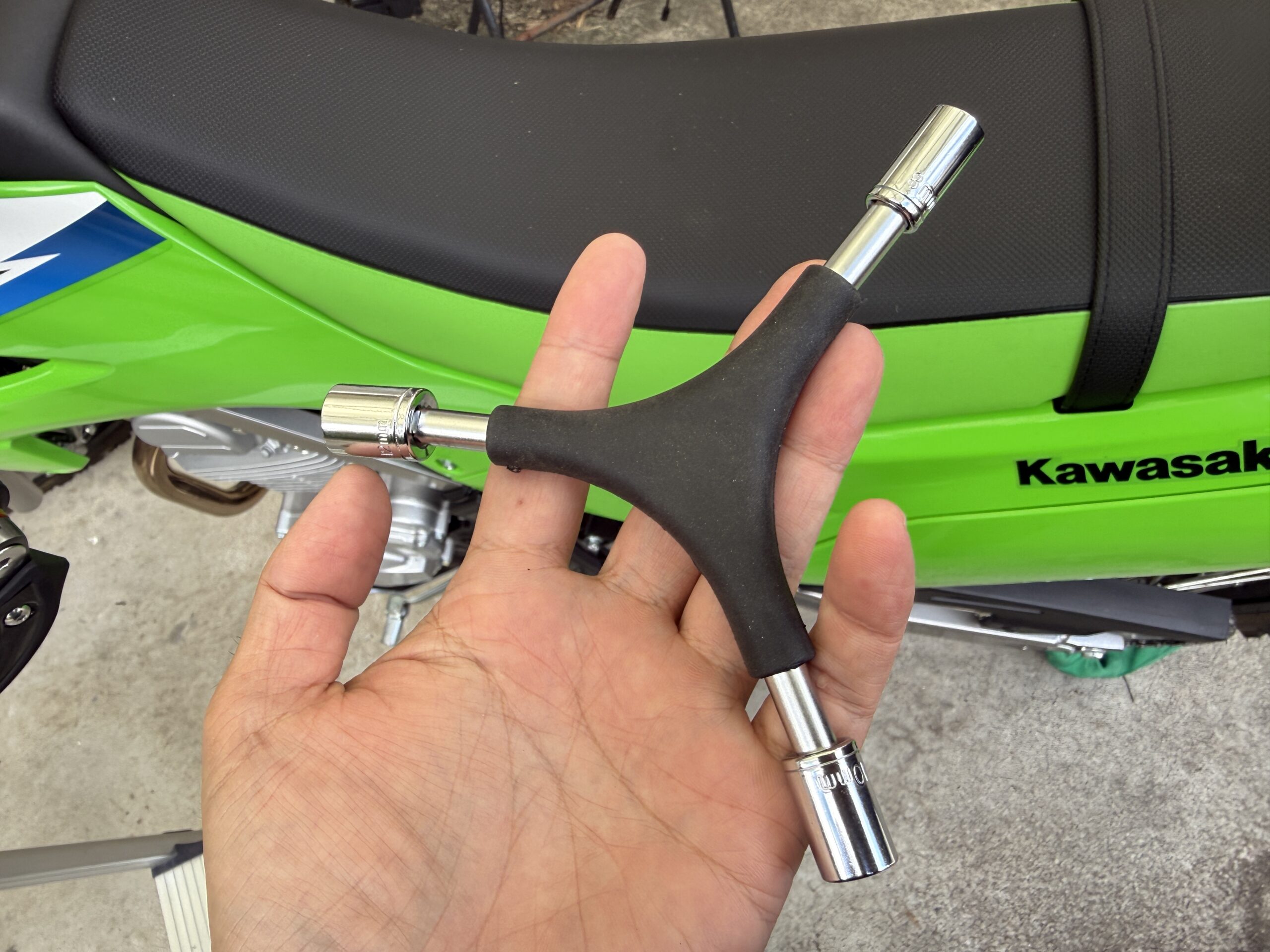 KLX230の前でエトスデザイン6in1 3WAYレンチを手に持った様子
