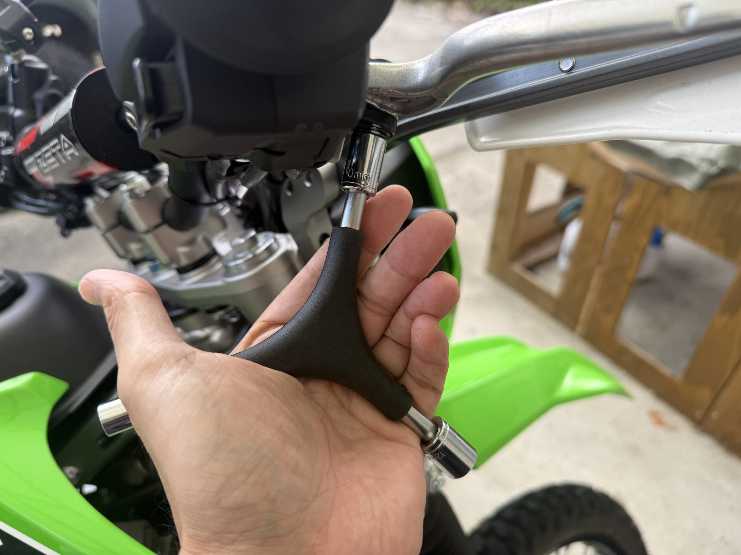 KLX230のレバーホルダーのボルトに10mmソケットを掛けた様子